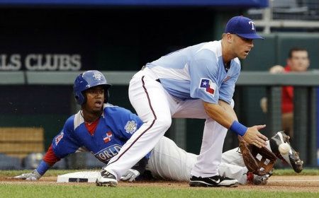 World's Jean Segura slide safely into third base against United States' Mike Olt on a single hit by Jurickson Profar during the third inning of the MLB All-Star Futures baseball game, Sunday, July 8, 2012, in Kansas City, Mo.