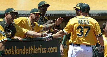 Brandon Moss #37 is congratulated by teammates after he hit a solo home run in the second inning against the Boston Red Sox at O.co Coliseum on July 4, 2012 in Oakland, California.