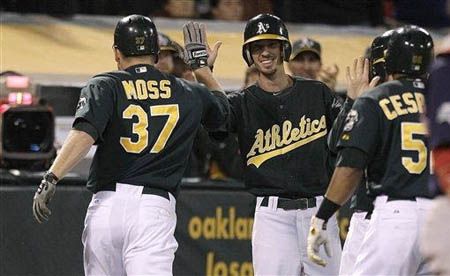 Oakland Athletics' Brandon Moss (37) is congratulated after hitting a two-run home run off Boston Red Sox's Alfredo Aceves in the inning of a baseball game Friday, Aug. 31, 2012, in Oakland, Calif. 
