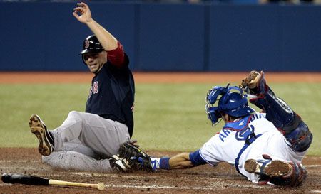 Daniel Nava #66 of the Boston Red Sox slides safely at home past J.P. Arencibia #9 of the Toronto Blue Jays during MLB action at the Rogers Centre June 1, 2012 in Toronto, Ontario, Canada. 