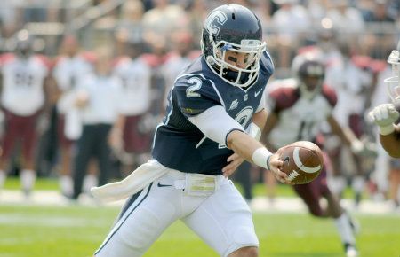 UConn's Michael Nebrich (No. 2) hands off the ball during the first half of UConn football opener at Rentschler Field against Fordham