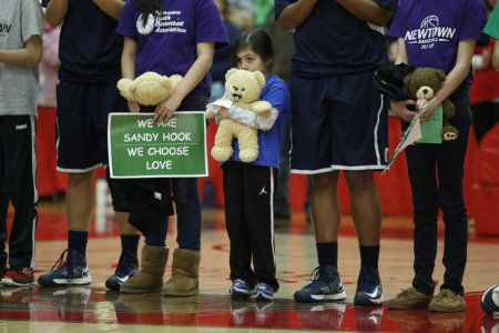 Before the start of the game at the Chase Family Arena, children from the Newtown youth basketball league join the Connecticut Huskies and the Hartford Hawks to remember those killed Dec. 14 at the Sandy Hook Elementary School. 
