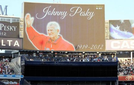 Fans observe a moment of silence for the late Johnny Pesky of the Boston Red Sox prior to the game between the New York Yankees and the Texas Rangers against the at Yankee Stadium on August 13, 2012 in the Bronx borough of New York City.