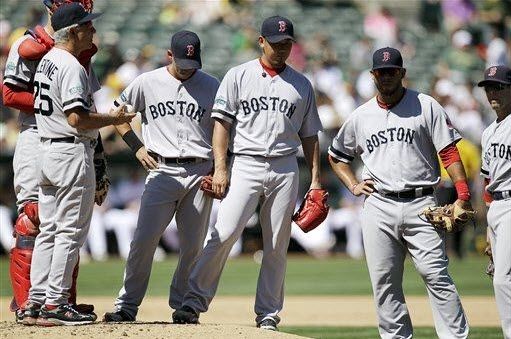 Boston Red Sox's Daisuke Matsuzaka, center, of Japan, waits to be relieved by Andrew Miller after being removed by manager Bobby Valentine in the fourth inning of a baseball game against the Oakland Athletics, Sunday, Sept. 2, 2012, in Oakland, Calif. Matsuzaka gave up six runs in 4 2/3 innings.