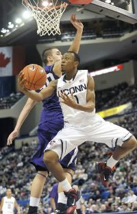 UConn's Ryan Boatright gets a shot off with Holy Cross' Dave Dudzinski defending at the XL Center