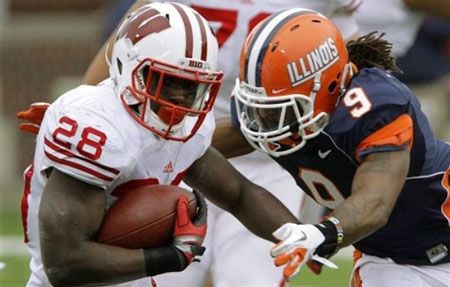 Wisconsin running back Montee Ball (28) runs with the ball against Illinois defensive back Tavon Wilson (9) during the first half of an NCAA college football game, Saturday, Nov. 19, 2011, in Champaign, Ill.