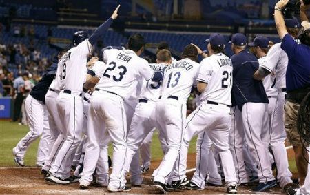 Members of the Tampa Bay Rays come out to meet B.J. Upton at home plate after he hit the game winning home run in the bottom of the ninth inning to give the Rays a 7-4 win over the Boston Red Sox in a baseball game Thursday, Sept. 20, 2012, in St. Petersburg, Fla. 