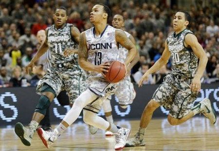 Connecticut guard Shabazz Napier (13) controls the ball against Michigan State's Keith Appling (11) and Travis Trice (20) during their NCAA men's basketball game on Saturday, Nov. 10, 2012, on the Ramstein U.S. Air Force Base, in Ramstein, Germany.