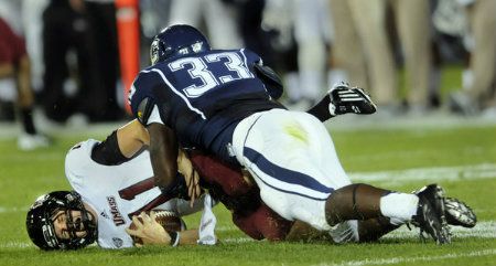 UMass QB Mike Wegzyn is sacked by UConn's (33) Yawin Smallwood in the 2nd quarter. 