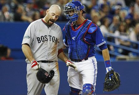 Boston Red Sox Kevin Youkilis (L) is held back by Toronto Blue Jays catcher J.P. Arencibia after he was hit by a pitch by Drew Hutchison (not seen) during the sixth inning of their MLB American League baseball game in Toronto, June 3, 2012.