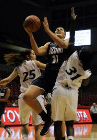 UConn's Stephanie Dolson splits the defense of Cincinnati guards Chelsea Jamison, left, and Dayeesha Hollins in the first hal