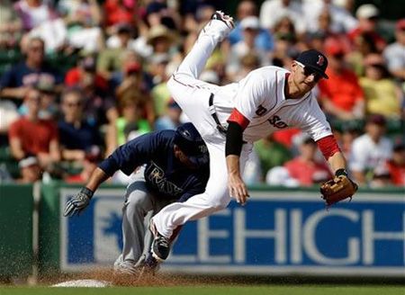 Boston Red Sox third baseman Will Middlebrooks, right, leaps as he misses a throw from catcher Jarrod Saltalamacchia, not pictured, allowing Tampa Bay Rays' Desmond Jennings, left, to score from third base during the third inning of an exhibition spring training baseball game, Saturday, Feb. 23, 2013, in Fort Myers, Fla
