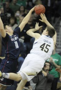 University of Connecticut Huskies forward Tyler Olander, 10, blocks a shot by Notre Dame Fighting Irish forward Jack Cooley, 45, during the first half. 
