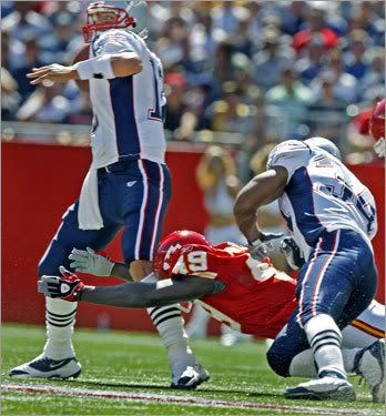 Brady gets hit by Pollard.  Photo by Jim Davis/Boston Globe