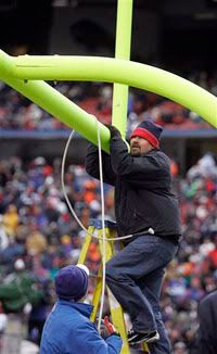 Stadium workers straighten a goal post that tilted in high winds during an NFL football game between the Buffalo Bills and New England Patriots at Ralph Wilson Stadium - AP Photo
