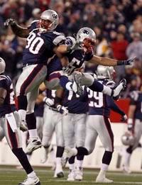 LeKevin Smith and Tedy Bruschi celebrate Smith's fumble recovery.  AP Photo.
