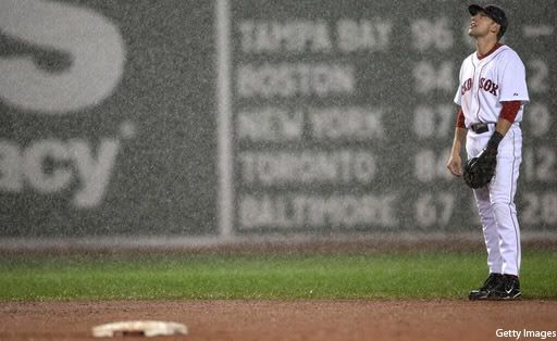 Jed Lowrie ponders why the Red Sox are playing in a pooring rain.