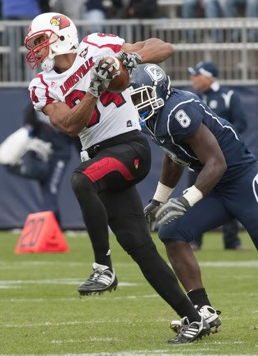 Louisville wide receiver Scott Long (84) carries the ball on a reception as Connecticut linebacker Lawrence Wilson (8) moves in for the tackle during the second half Saturday at Rentschler Field - AP Photo