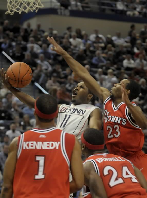 UConn's Jerome Dyson shoots over St. John's D.J. Kennedy, (1) Justin Burrell, (24) and Paris Horne (23) in the second half of their men's basketball game at the XL Center in downtown Hartford Wednesday Jan. 20 2009. UConn beat St. John's 75-59 - Bettina Hansen/Hartford Courant