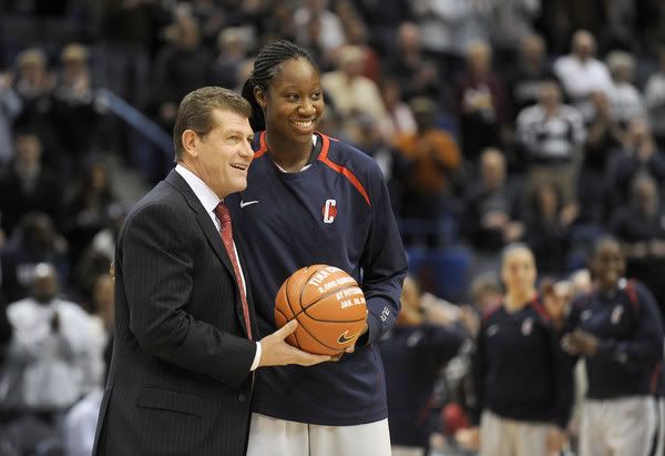 UConn head coach Geno Auriemma holds a basketball with Tina Charles to commemorate her scoring her 2000th point last weekend against Pittsburgh. The UConn women played West Virginia at the XL Center - John Woike/Hartford Courant