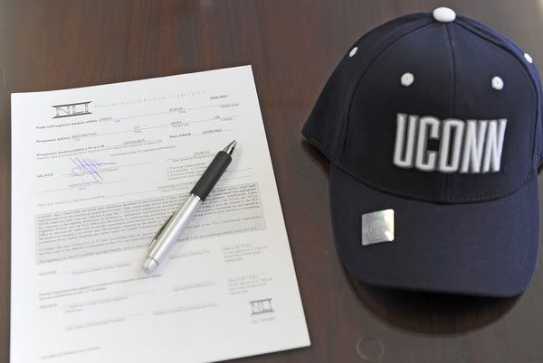 Byron Jones' signed letter of intent and the hat of his new team sit on a desk following a ceremony at St. Paul High in Bristol on Wednesday - John Woike/Hartford Courant