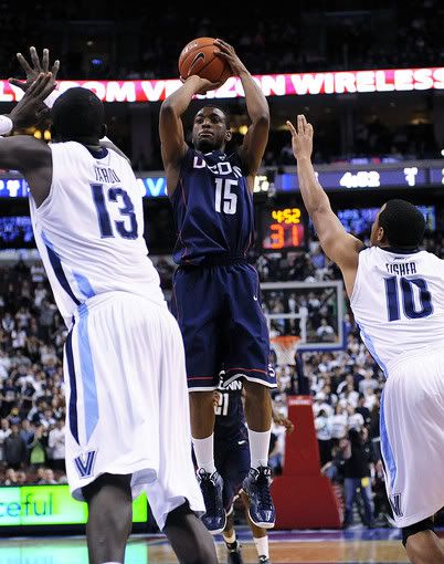 Connecticut guard Kemba Walker (15) shoots over Villanova's Mouphtaou Yarou (13), of Benin, and guard Corey Fisher in the second half of an NCAA college basketball game in Philadelphia. Connecticut won 84-75 (Michael Perez/AP Photo)