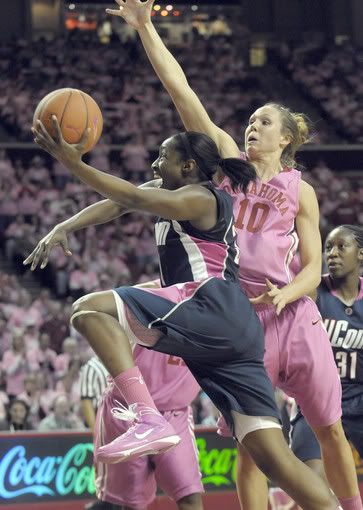 Kalana Greene of UConn draws the foul and makes the hoop as Carlee Roethlisberger of Olahoma defends during the second half. Greene scored 14 points and grabbed 6 rebounds as the Huskies won 76-60. (John Woike/Hartford Courant)