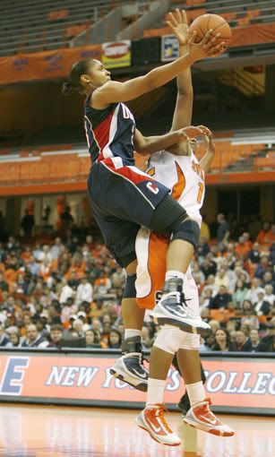 Maya Moore finishes off a fastbreak layup despite the defensive efforts of Syracuse's Juanita Ward in the second half. Moore had 38 points and 20 rebounds as the Huskies won their 67th consecutive game (Michael McAndrews/Hartford Courant)