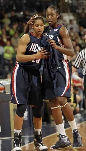Connecticut center Tina Charles, right, pats her teammate forward Maya Moore on the head as they leave the court late in the second half of an NCAA college basketball game with Notre Dame - Joe Raymond/AP Photo
