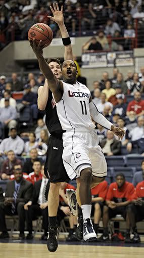 Jerome Dyson of UConn slips past Matt Janning of Northeastern and misses an easy layup during the first half of the NIT opening-round game Tuesday at Gampel Pavilion. Dyson went 1-for-6 for five points in the half (John Woike/Hartford Courant]