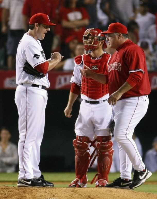 Los Angeles pitcher John Lackey (L) is pulled from the game by Angels manager Mike Scioscia (R) as catcher Jeff Mathis watches during the seventh inning in Game 5 of their Major League Baseball ALCS playoff series against the New York Yankees in Anaheim, California October 22, 2009 - Reuters Photo