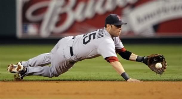 Boston Red Sox second baseman Dustin Pedroia dives for a ball hit by Los Angeles Angels' Bobby Abreu during the first inning of Game 2 of the American League division baseball series, Friday, Oct. 9, 2009, in Anaheim, Calif. Abreu was out at first on the play - AP Photo