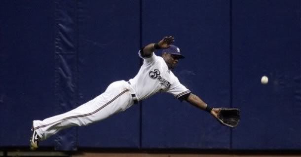 Milwaukee Brewers' Mike Cameron tries to make a diving catch on Chicago Cubs' Derrek Lee's double during the sixth inning of a baseball game Monday, Sept. 21, 2009, in Milwaukee. - AP Photo