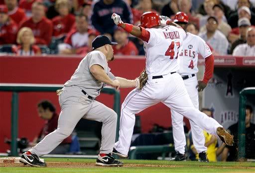Boston Red Sox first baseman Kevin Youkilis tags Los Angeles Angels' Howie Kendrick after taking the wide throw at first during the fourth inning in Game 1 of the American League division baseball series Thursday, Oct. 8, 2009 in Anaheim, Calif. Umpire CB Bucknor called Kendrick safe. (AP Photo/Jae C. Hong)