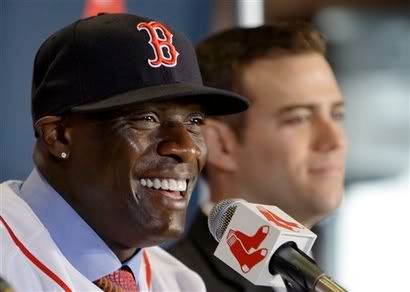 , left, smiles as he sits next to Red Sox general manager Theo Epstein during a baseball news conference at Fenway Park in Boston, Wednesday, Dec. 16, 2009. Cameron signed a two-year contract with the Red Sox worth a reported $7 million to $8 million a season. - AP Photo