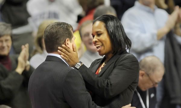 Jamelle Elliott, former UConn championship player and assistant coach, gives her former boss, Geno Auriemma, a face squeeze at the end of the game - Stephen Dunn/Hartford Courant