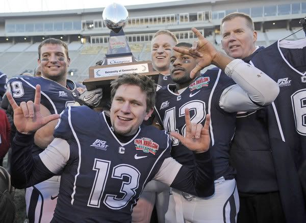 The four UConn captains -- Anthony Sherman, Desi Cullen, Scott Lutrus and Robert McClain -- salute Jasper Howard as they hold the championhip trophy with head coach Randy Edsall after the Huskies defeated South Carolina 20-7 in the 2010 Papajohns.com Bowl in Birmingham, Ala., on Saturday afternoon - John Woike/Hartford Courant