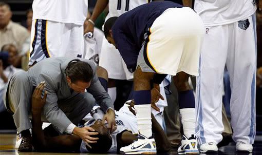 Memphis Grizzlies head athletic trainer Drew Graham attends to Memphis Grizzlies center Hasheem Thabeet during the first quarter of an NBA basketball game against the Portland Trail Blazers on Tuesday, Nov. 10, 2009, in Memphis, Tenn. Thabeet was taken out of the game with a fractured jaw. (AP Photo/Alan Spearman)