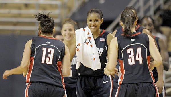  UConn's Maya Moore, center, welcomes in teammates Jacquie Fernandes, left, and Kelly Faris, right, at the half. the Huskies had a 52-22 halftime lead en route to an 87-34 victory over Holy Cross in Worcester - Bettina Hansen/Hartford Courant