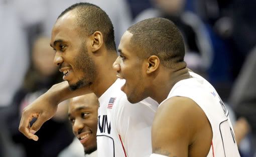 At the end of the game, UConn's Kemba Walker, left, and Alex Oriakhi, right, congratulate teammate Charles Okwandu for his good game against Notre Dame at the XL Center on Saturday - Stephen Dunn/Hartford Courant
