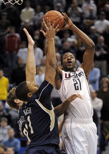 UConn's Stanley Robinson, right, scores two points while being guarded by Notre Dame's Tim Abromaitis, left, and Tyrone Nash during the first half on Saturday, Jan. 2, 2010 - AP Photo