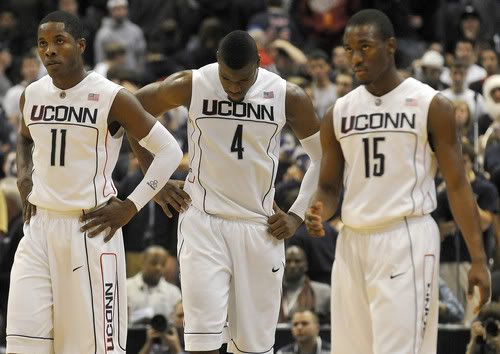 Jeff Adrien, center, hangs his head after a stinging 74-63 to Georgetown Monday night at the XL Center while Jerome Dyson, left, and Kemba Walker stare at the scoreboard - Hartford Courant Photo