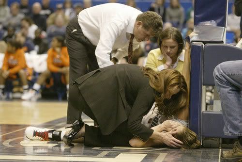 Geno Auriemma and trainers huddle over Caroline Doty after she injured her knee in the first half - MICHAEL MCANDREWS / HARTFORD COURANT